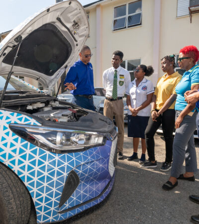 JPS business development manager Richard Gordon (left), who is also the project manager for the JPS EV charging infrastructure, explains the mechanics of an electric vehicle Dominic Stewart, Abigale Pratt and Ryana Earle as JPS Foundation head Sophia Lewis and Andre Coye, associate dean of external engagement in the Faculty of Science and Technology at the University of the West Indies (UWI) look on.